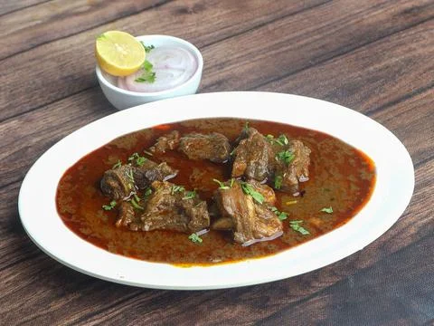 Mutton curry or Lamb curry, spicy and delicious dish served over a rustic woo Stock Photos