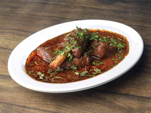 Mutton curry or Lamb curry, spicy and delicious dish served over a rustic woo Stock Photos