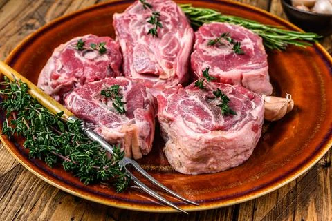 Mutton lamb neck meat on a rustic plate with thyme and rosemary. wooden Stock Photos