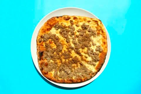 Mutton minced meat Manakeesh on blue background. Stock Photos