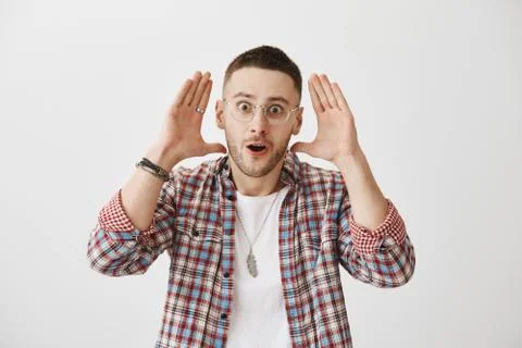 My brain explodes from this gossips. Studio shot of shocked and excited handsome Stock Photos