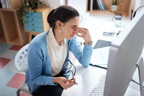 My brain might explode. a young businesswoman looking stressed while using a Stock Photos