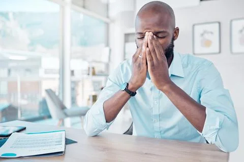 My head is about to explode. a young businessman looking stressed at work. Foto stock
