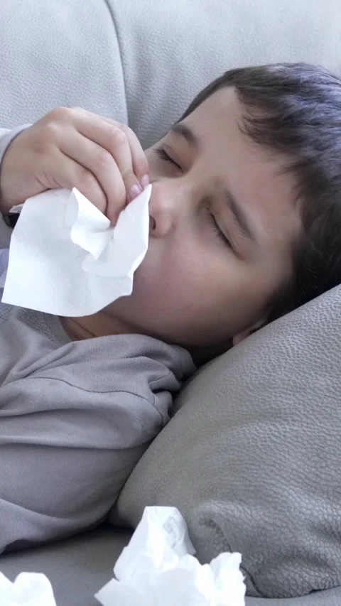 My nose wont stop dripping. Shot of a child feeling ill in couch Vidéo 337033809
