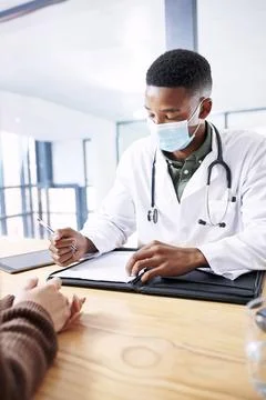 My patient and I need to be on the same page. a young doctor sitting with his Stock Photos