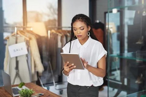 My tablet makes it easier to connect with my clientele. Cropped shot of a young Fotos Stock
