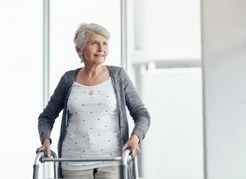 My walker helps me to get around. a senior woman walking with the assistance of Stock Photos