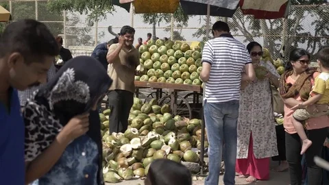 MYSORE, India - man chops open fresh coconuts at stall Stock Footage 84166490