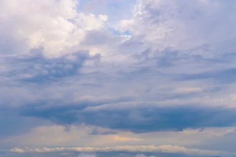 Mysterious clouds drift across a light blue sky at dusk revealing hints of Stock Photos