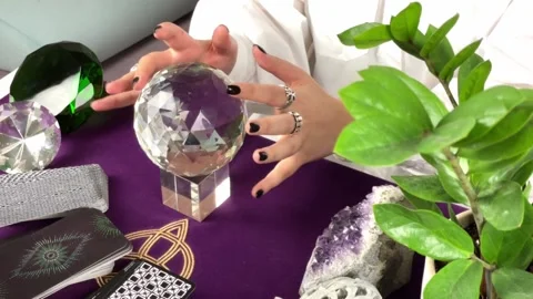 Mysterious fortune teller's hands making magic movements above a crystal ball Stock Footage 168326881