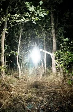 Mysterious Glowing Object Hovering in Forest Glade Stock Photos