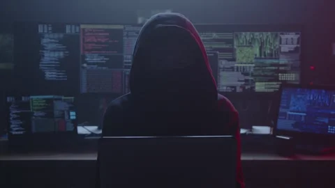Mysterious Hacker in Darkened Environment with Multiple Screens Stock Footage 281759811