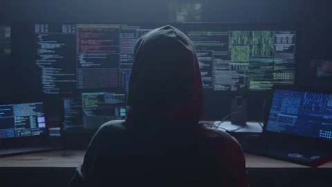 A Mysterious Hacker Operates in a Dark Room, Surrounded by Multiple Screens Stock Footage 281759830