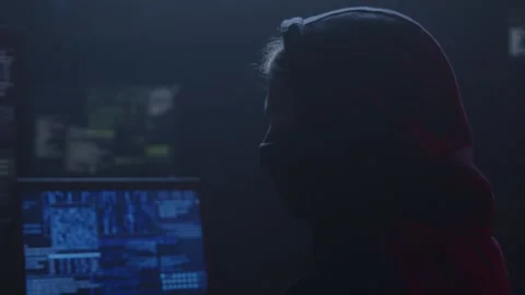 A Mysterious Hacker Sits in a Dark Room Surrounded by Screens Stock Footage 281759433