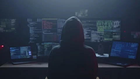 A Mysterious Hacker at Work, Enveloped by Multiple Monitors Displaying Data Stock Footage 281759867