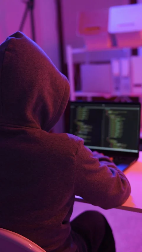 A mysterious hacker working on a computer in a dark room. Stock Footage 331989777