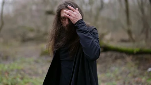 Mysterious long-haired man with sword in forest, magician or fighter Vídeos de archivo 168333022