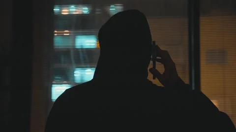 Mysterious man with back to camera standing by apartment window talking on phone Stock Footage 330303277