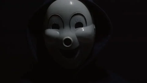 Mysterious man on a black background. Hacker in a mask with a closed face. Video stock 145758568
