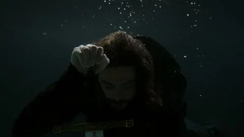 Mysterious man with medieval sword inside depth of sea, portrait underwater shot Video stock 167277819