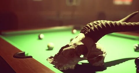 Mysterious pool table with skull and billiard balls in dimly lit room Illustrazione stock