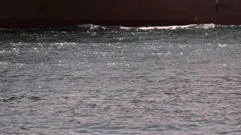 A mysterious ship with only its bottom visible sails across the sparkling sea. Stock Footage 278179924