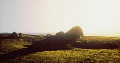 Mysterious stone structure casting a long shadow on grassy landscape at sunse Stock Illustration