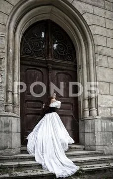 Mysterious woman in Victorian dress with old doors Stock Photos