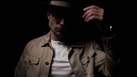 Mysterious young man fixing hat, sensually touching neck, looking to side and Stock Footage 138809791