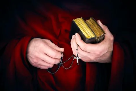 Mystery monk with a cape holding bibles and a black rosary Foto stock