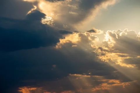 Mystical dramatic cloudy sky with sun behind the clouds and rays of light .Sk Stock Photos