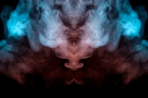 Mystical pattern of orange and blue colored smoke in the shape of a ghost's f Stockfoto's