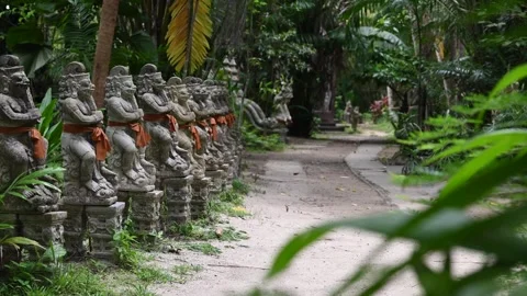Mystical tropical temple path with stone statues in lush jungle Thailand Vidéo 336775398