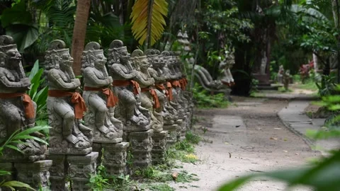Mystical tropical temple path with stone statues in lush jungle Thailand 库存影片 336775399