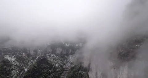Mystical view of snow dusted rocks, view from cable car moveing up into clouds Stock Footage 321237459