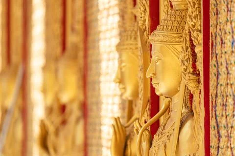 Mythical protector figures across temple wall gilded high relief gold surfa.. Stock Photos