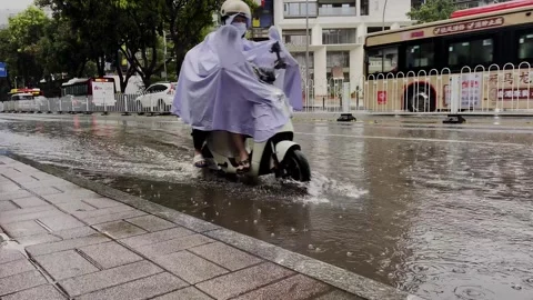 N electric scooter passing through a deep puddle on a rainy day,4K Stock-Footage 278603218