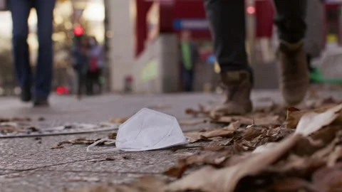 N95 mask laying on ground, get trampled, city - Coronavirus Covid-19 Epidemic Stock Footage 165690132