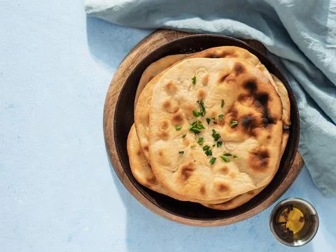 Naan flatbread on blue, copy space, top view Stack of fesh naan breads in ... Foto stock