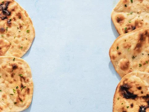 Naan flatbread on blue, copy space, top view Pattern of fesh naan bread on... Stock Photos