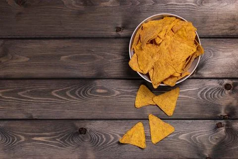 Nachos, corn chips on a deep white plate. Wooden background. The view from th Stock Photos