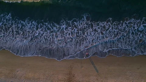Nadir shot of dark ocean waves crashing into white foam patterns on wet sandy Video stock 336333577