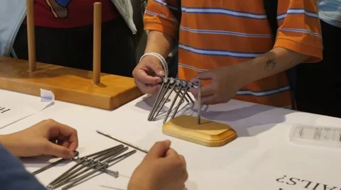 Nail balancing puzzle at a science fair. Stock Footage 50026872