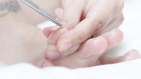 Nail care process, manicurists hands using scissors, trimming toenails against Stock Footage 308522317
