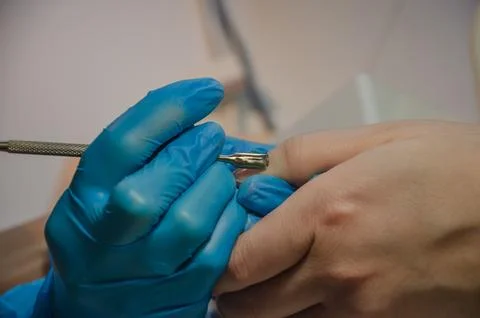 Nail care with a pusher tool. remove the cuticle with a scraper Stock Photos