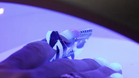 Nail extension form under UV lamp during gel curing Stock Footage 308516536