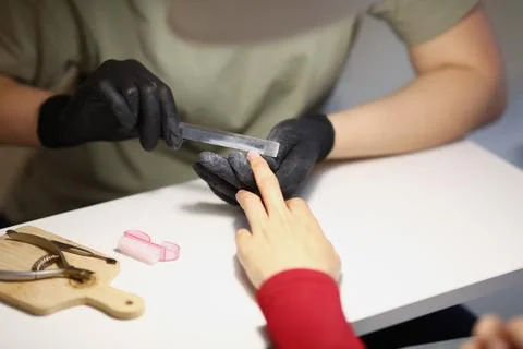 Nail master using nail file tool to create perfect shape for clients nails Stock Photos