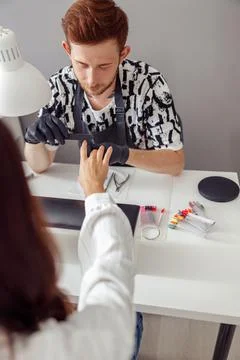 Nail master working on client nails at beauty center Stock Photos