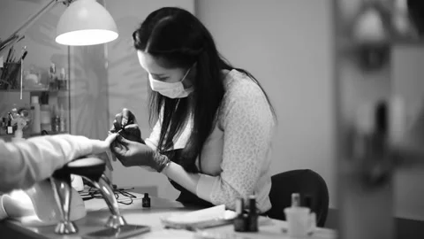 Nail master working in salon beauty. Professional nail and skin care black and w Stock Footage 236861916