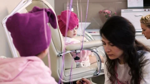 Nail masters doing pedicure for two pretty little girls in professional salon Stock Footage 73908648
